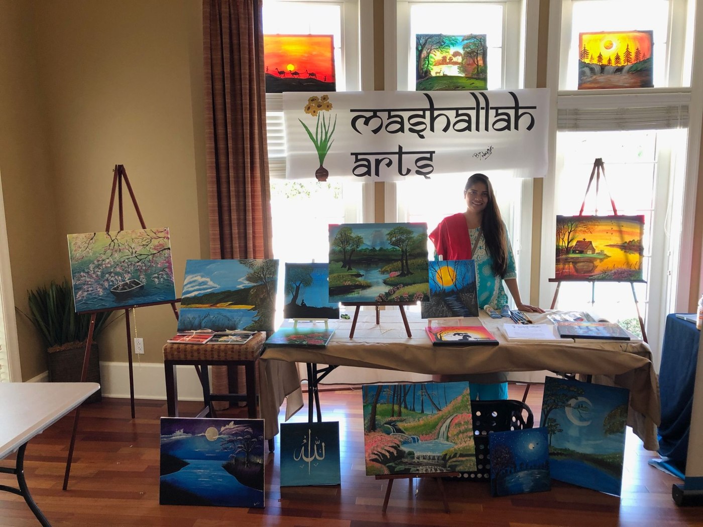 Nargis at a Mashallah Arts market pop-up, surrounded by her original paintings